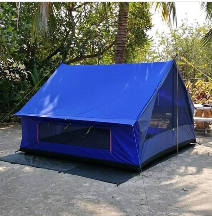 Blue camping tent pitched under palm trees